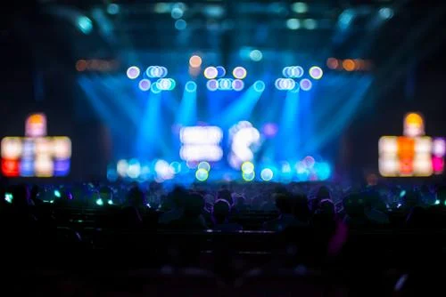 Scène de concert éclairée par des projecteurs bleus devant le public