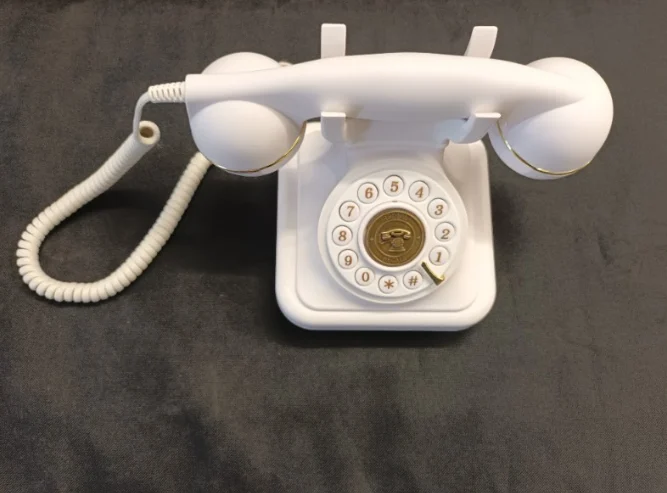 Téléphone vintage blanc à cadran, utilisé comme livre d’or audio